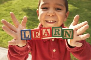 toddler holding blocks spelling 'learn'