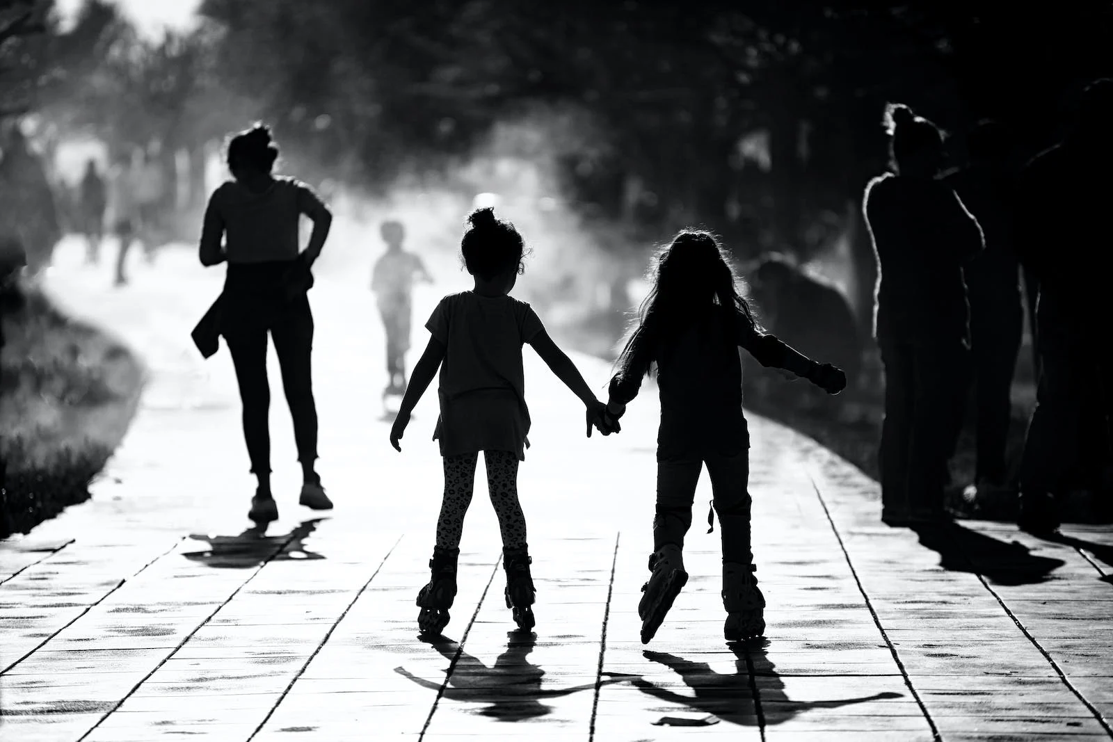 silhouette of young girls rollerblading