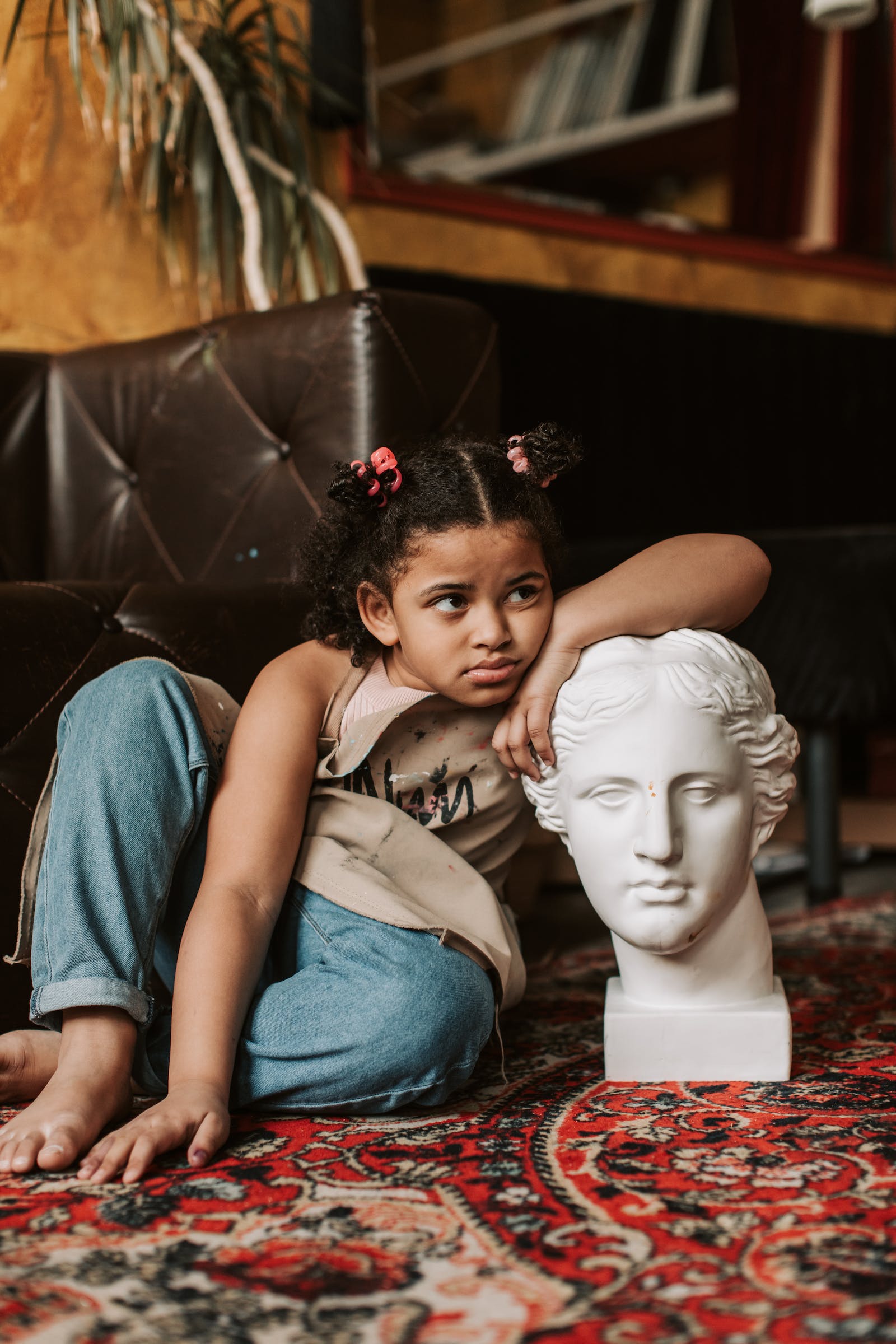 young girl leaning on head bust