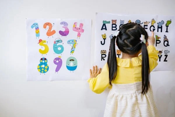 back of young girl working with numbers and letters