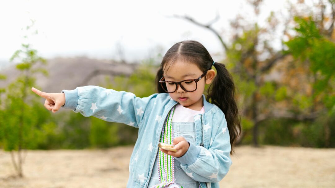 girl holding compass and pointing