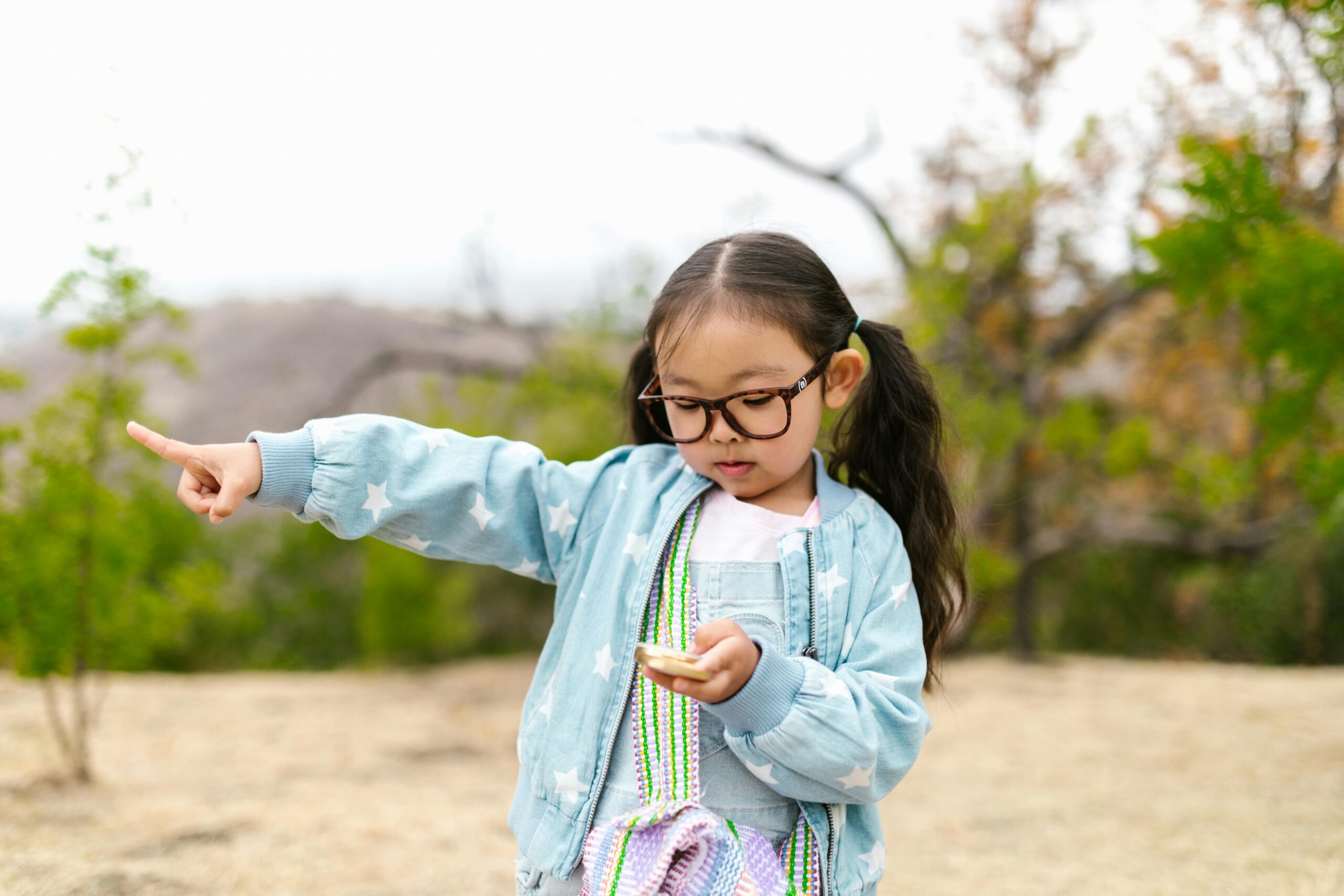 girl holding compass and pointing